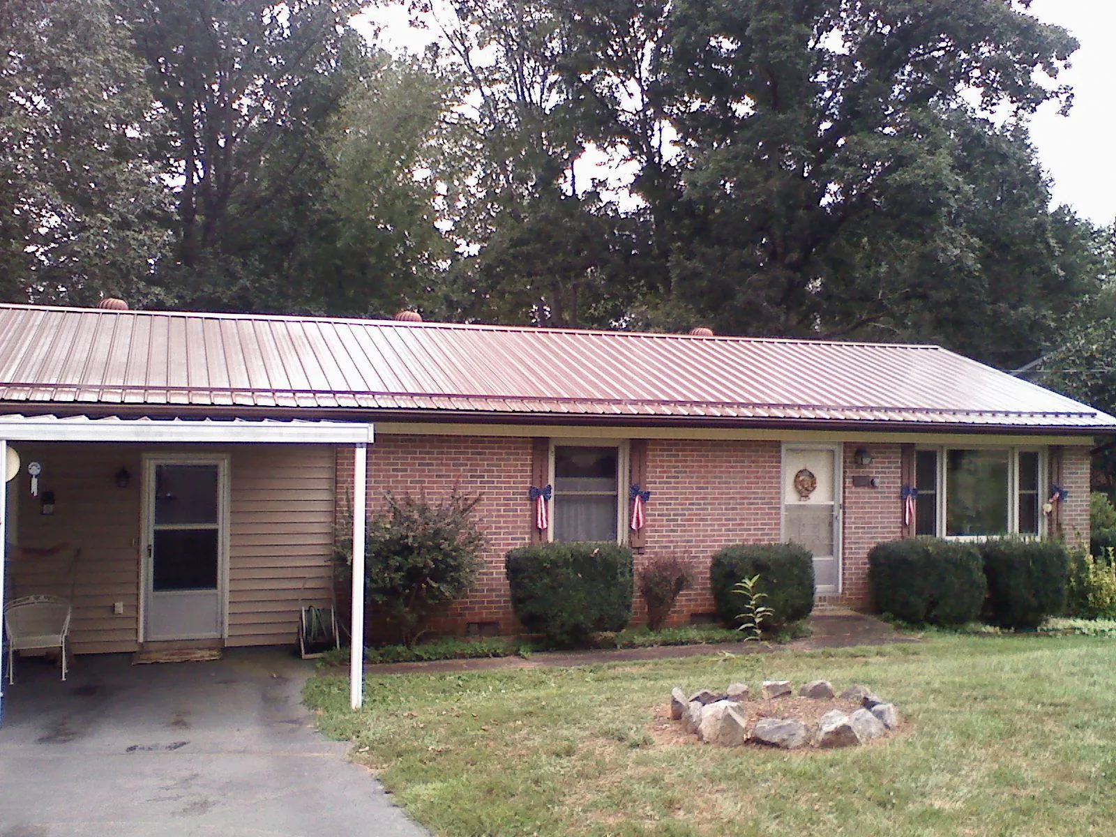 Bronze metal roof and carport on a brick ranch home — Roof Repair work by our crew in Brevard