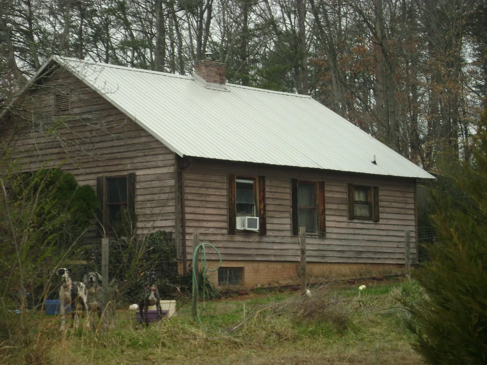 White metal roof on an old wood sided farmhouse, from a Metal Roof Installation job in Brevard